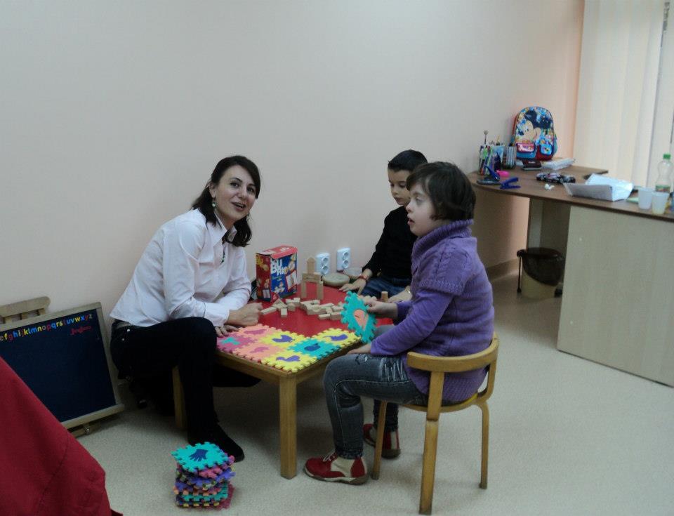 L'orthophoniste du centre avec deux enfants bénéficiaires